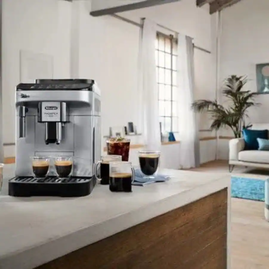 De’Longhi Magnifica Evo on a kitchen island beside three coffees