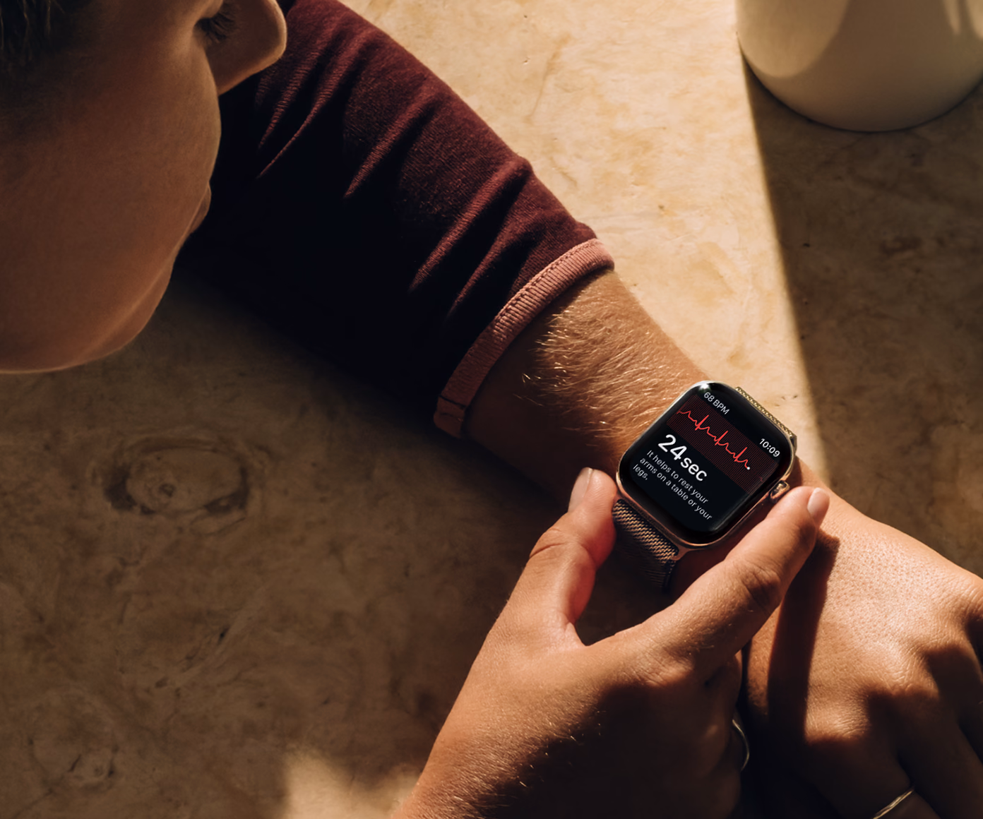 A person taking an ECG reading on Apple Watch Series 12, with the waveform and a 24-second countdown on screen